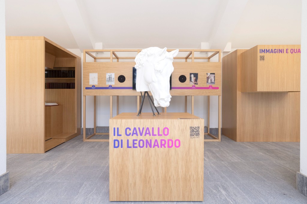 GAMI — Il Cavallo di Leonardo: white horse head sculpture on an oak plinth in front of the timeline structure