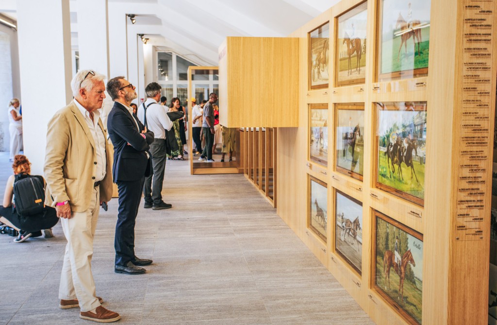 GAMI — visitors looking at the wall of framed racehorse paintings from the archive