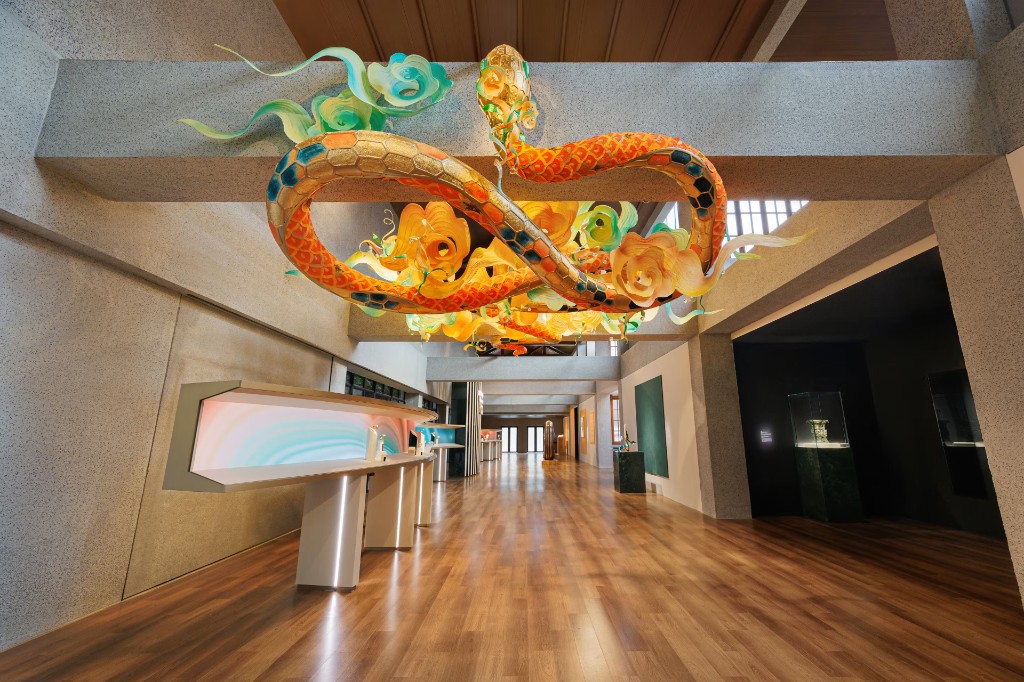 Human as a Catalyst — suspended serpent sculpture above the interactive stations