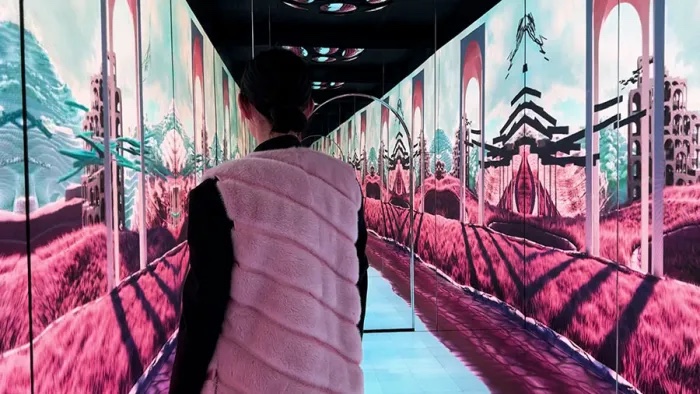 Masters of Materials — guest in a shearling gilet walking through a pink dreamscape of hills and arches